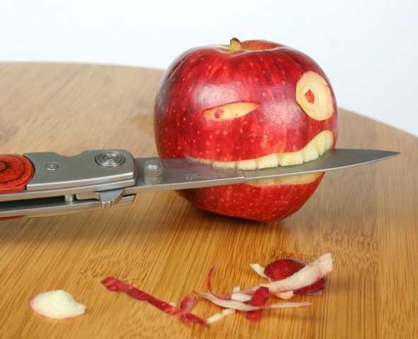 funny photo of apple eating knife picture of apple with knife foto photograph
